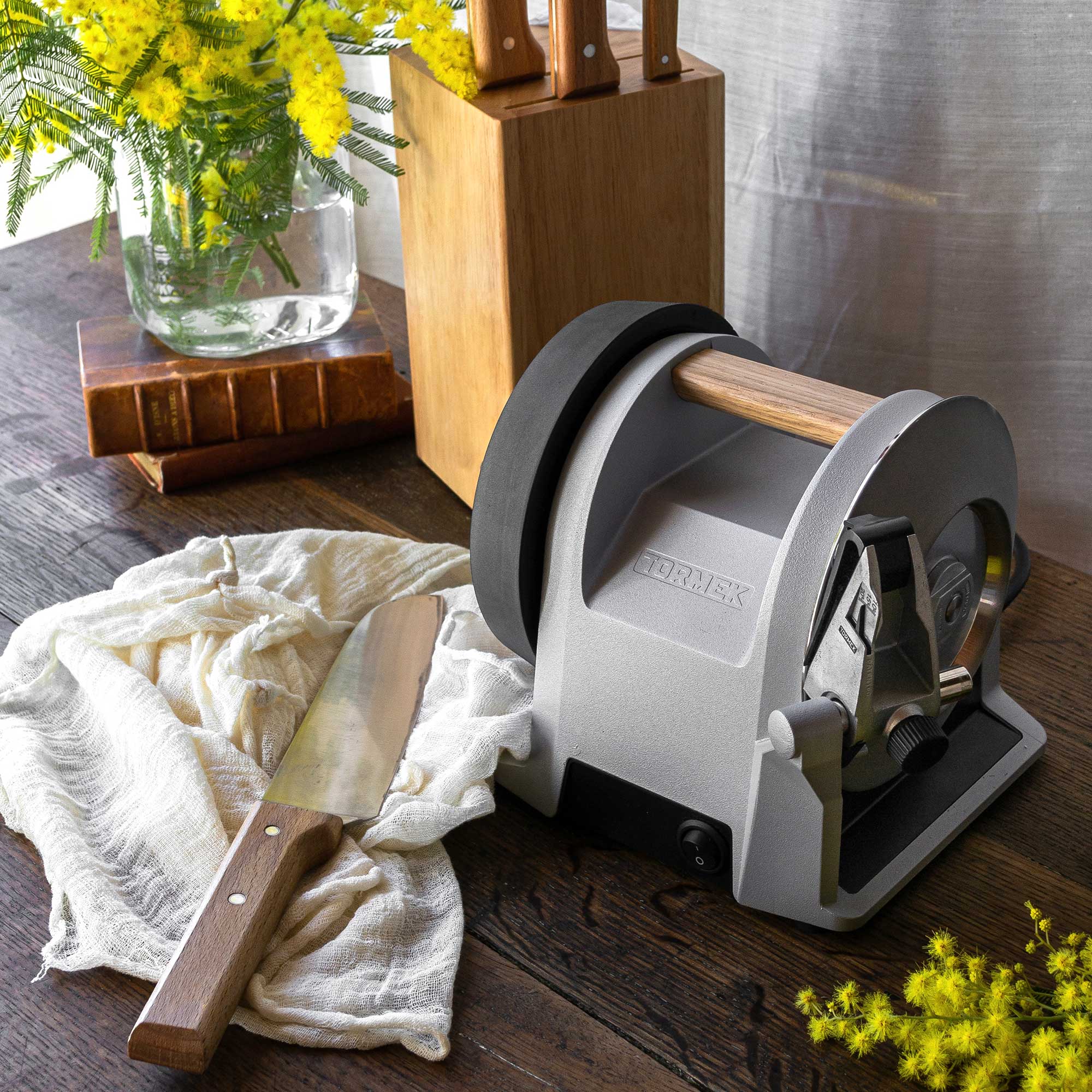 Tormek T-1 Zinc Gray at a kitchen table with a knife beside it. 