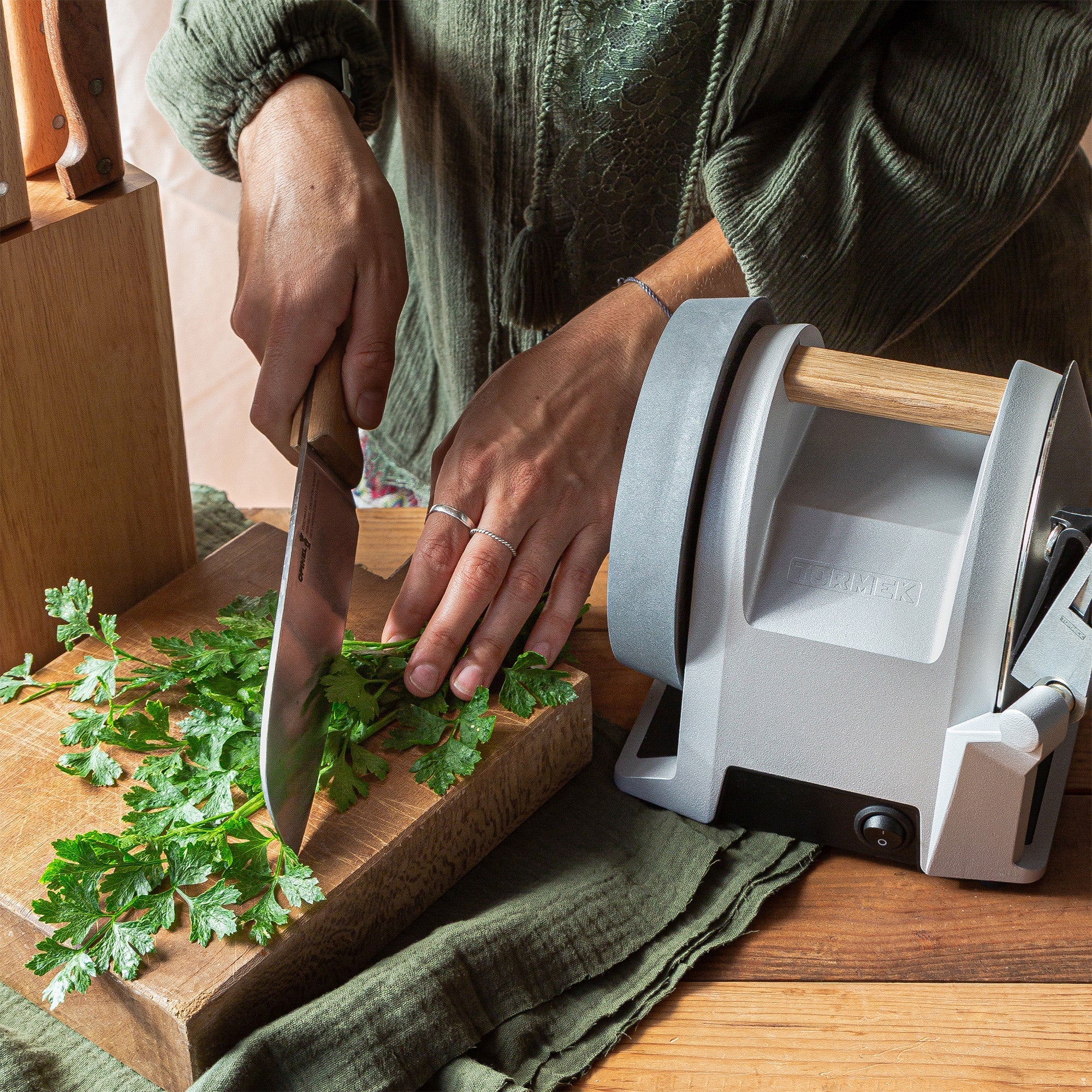 A person cutting herbs on a cutting board beside a Tormek T-1 Zinc Gray